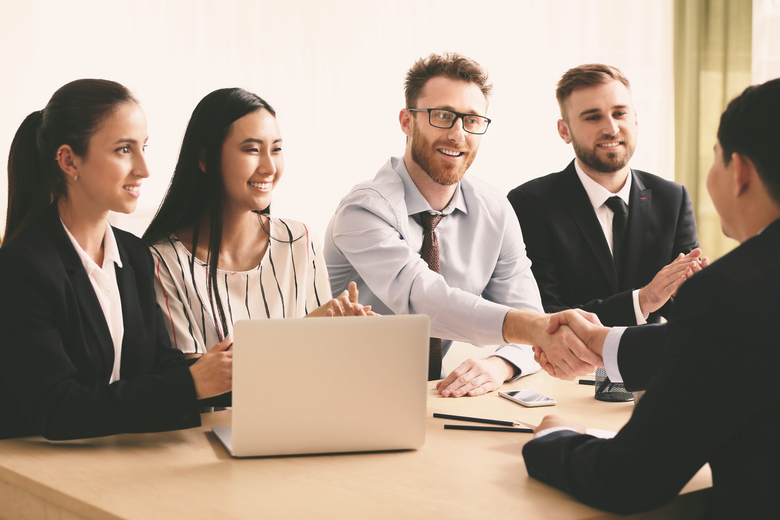 Human resources manager shaking hands with applicant after succe