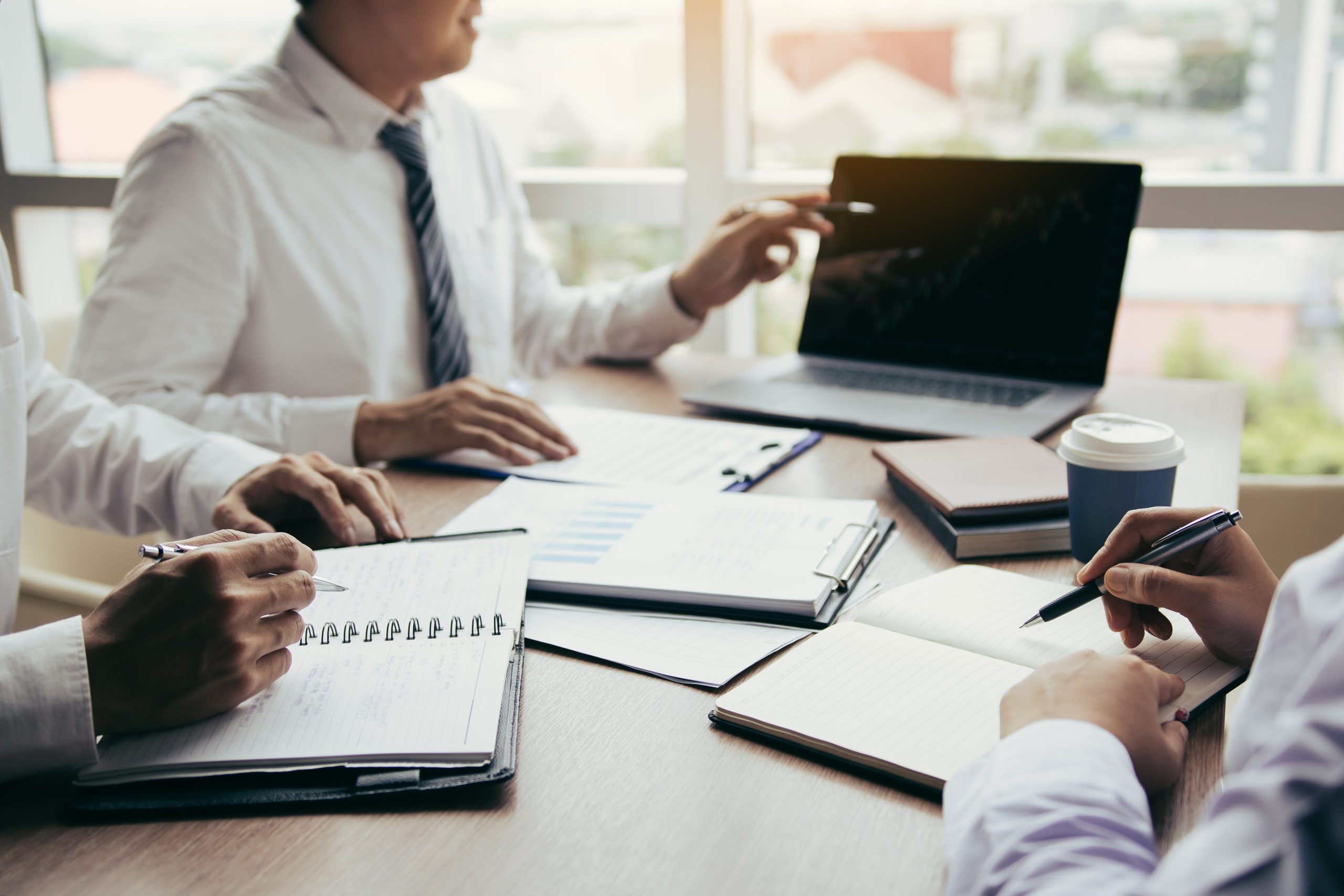 Businessman point to the laptop looking graph of the company fin